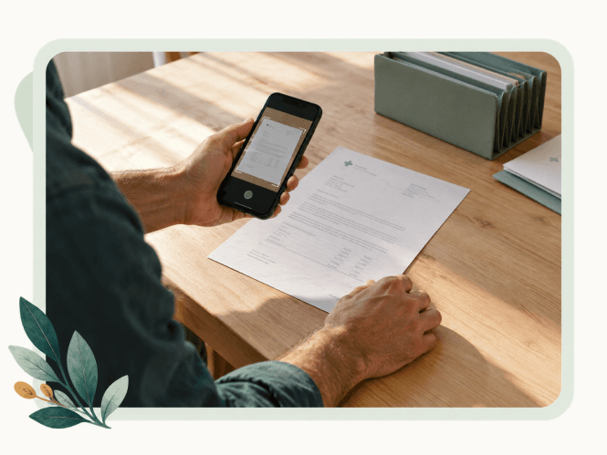 A man photographing a letter at a kitchen table